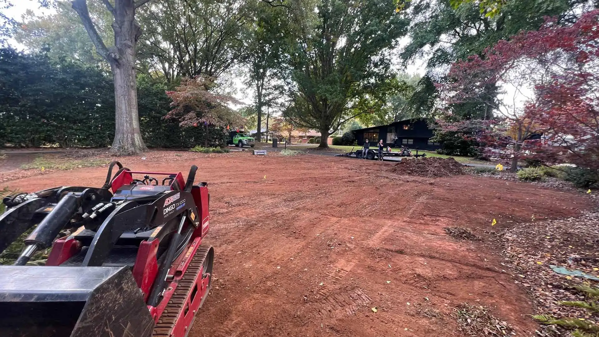 A lawn is being graded by a bobcat for proper drainage in Matthews, NC.