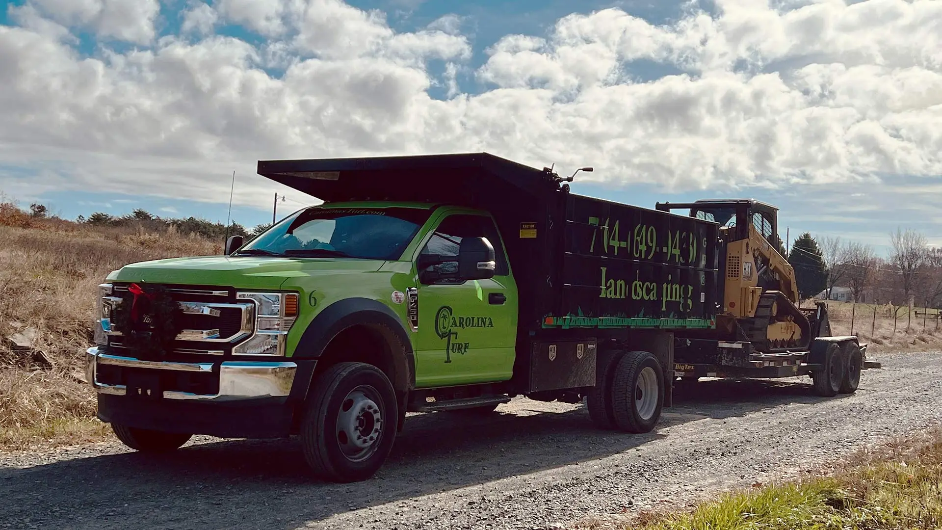 Carolina Turf Lawn and Landscape truck with a bobcat on a trailer on the way to a job in Matthews, NC.