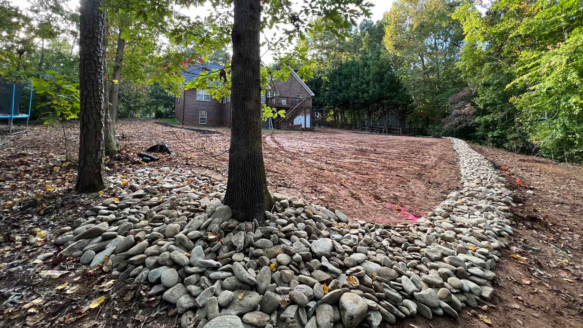 A new landscaping project underway with rocks installed and the lawn dug up in Matthews, NC and nearby areas.