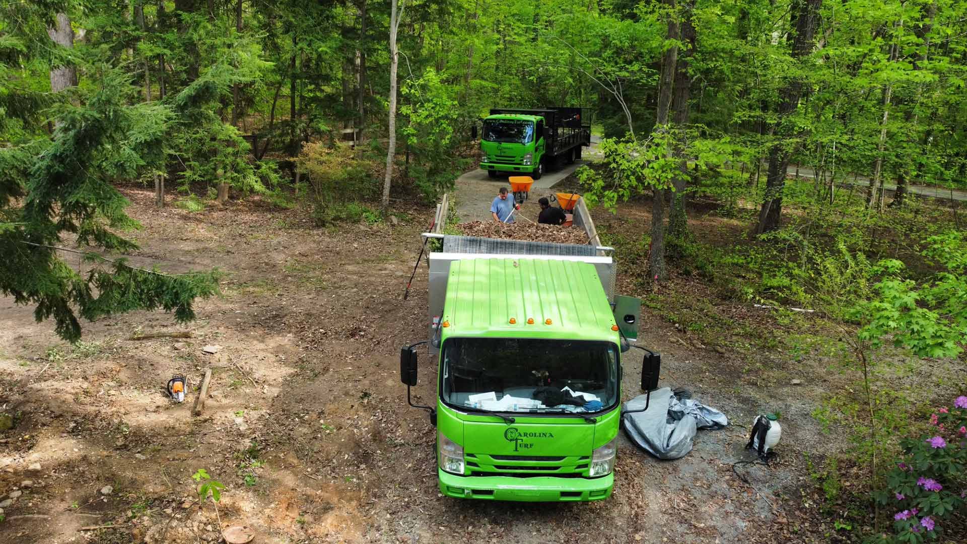 A landscaping crew loading leaves and debris into a company truck near Ballantyne, NC.