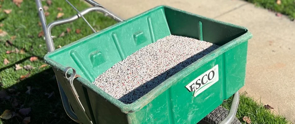 Broadcast spreader in Matthews, NC, with granular fertilizer.