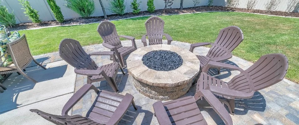 Lawn in Matthews, NC, next to a patio with fire pit and chairs.
