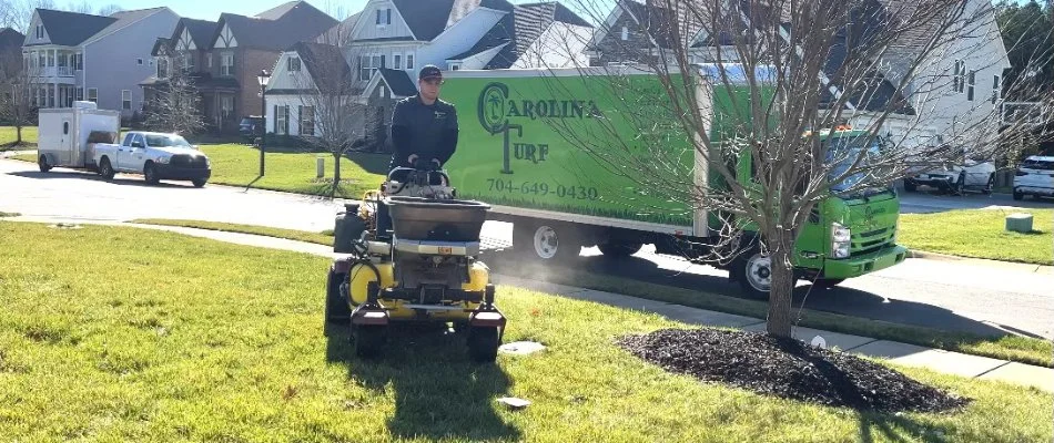 Professional providing lawn care service to a lawn in Matthews, NC.