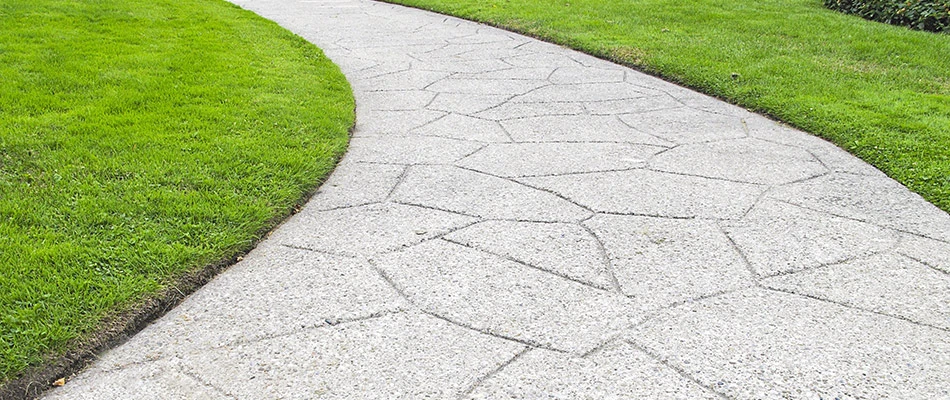 A string-trimmed and edged lawn along a side walk that looks prestine.