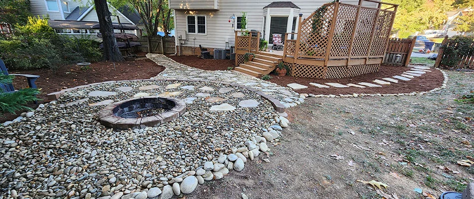 Beautiful fire pit surrounded by a stone and rock seating area in Matthews, NC.
