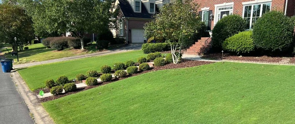 Healthy, green front lawn of a residential property in Huntersville, NC.