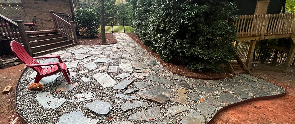 Flagstone and rock patio with a chair and still being installed.