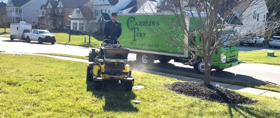 Professional applying a lawn care treatment on grass in Monroe, NC.