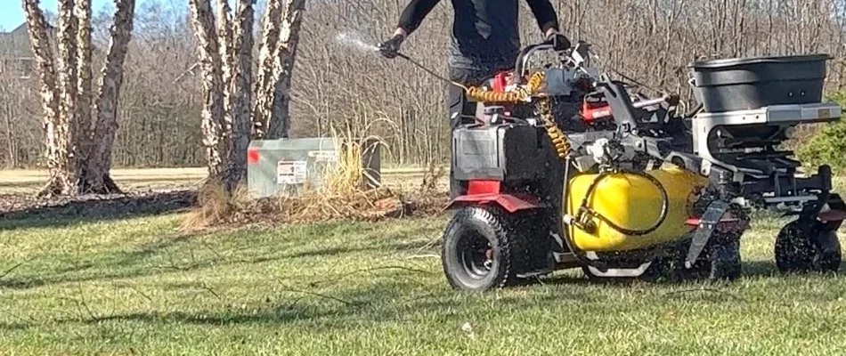 A professional providing lawn care services to a lawn in Pineville, NC.