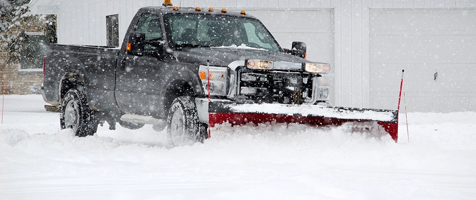 Snow plow truck clearing snow at a residential property in Mathews, NC.